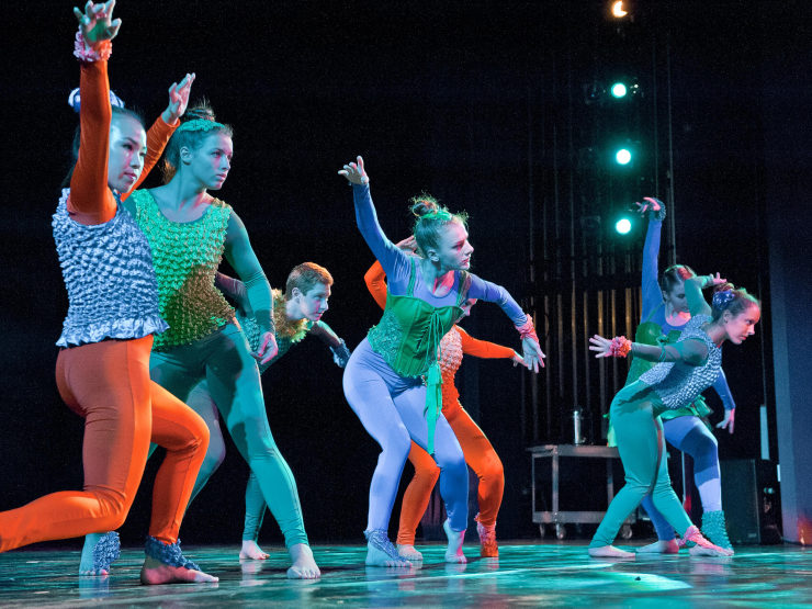 Group of female dancers performing on stage in costume acting like marionettes