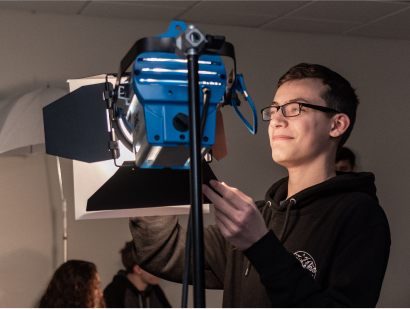 Male student adjusting the lighting on a film set