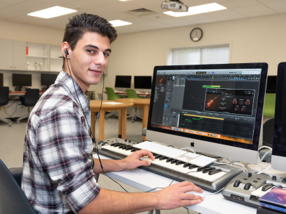 Male student creating music on the computer