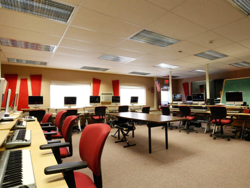 Computer lab with rolling chairs and desks and computers