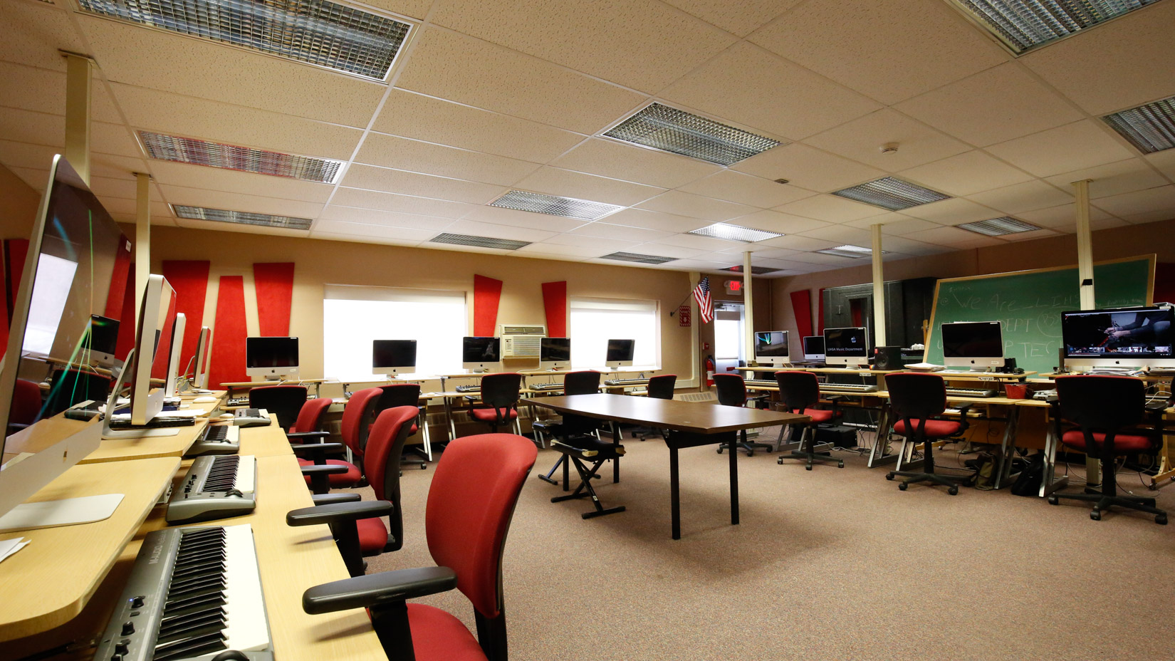 Computer lab with rolling chairs and desks and computers