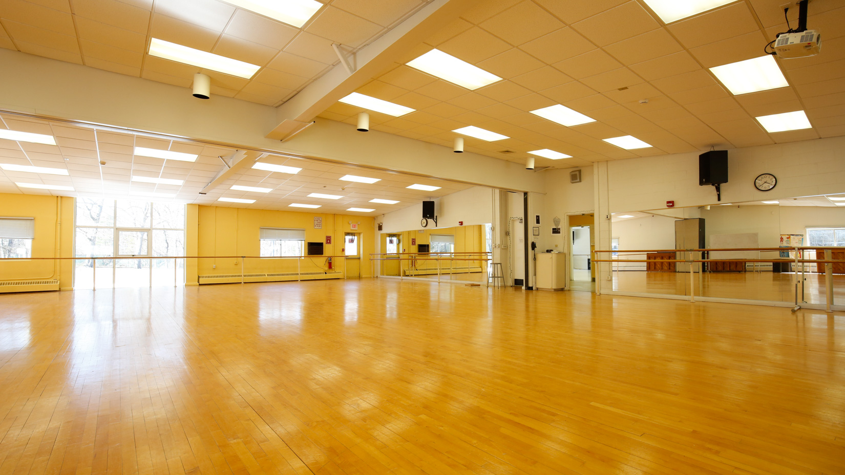 Large dance studio with mirrored walls and wooden floors