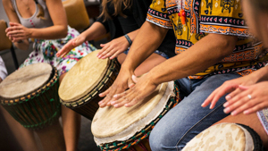 Many hands drumming on drums