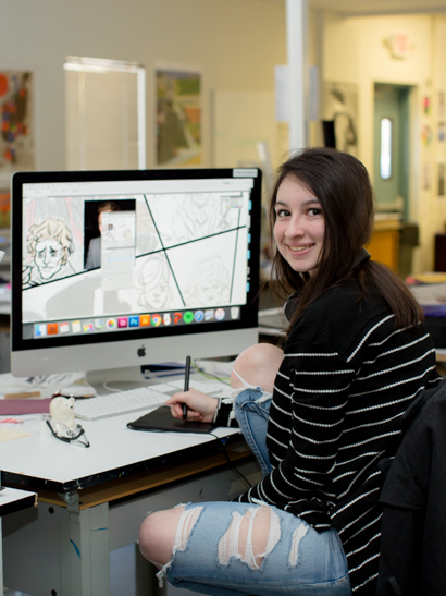 Female student drawing using a digital tablet on the computer