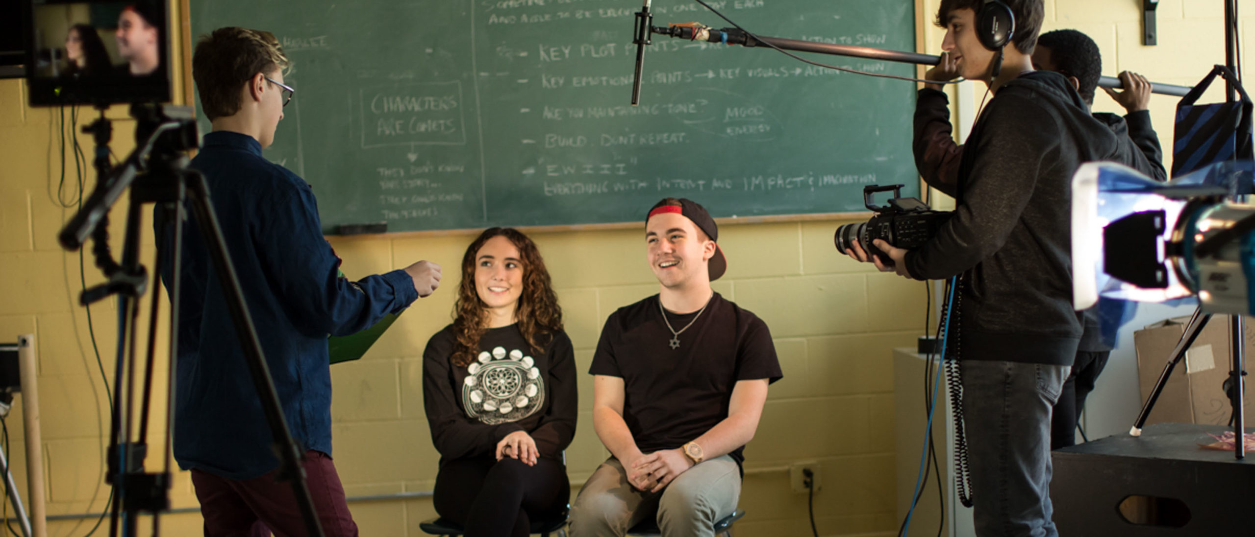 Two students being interviews as film students film and direct them