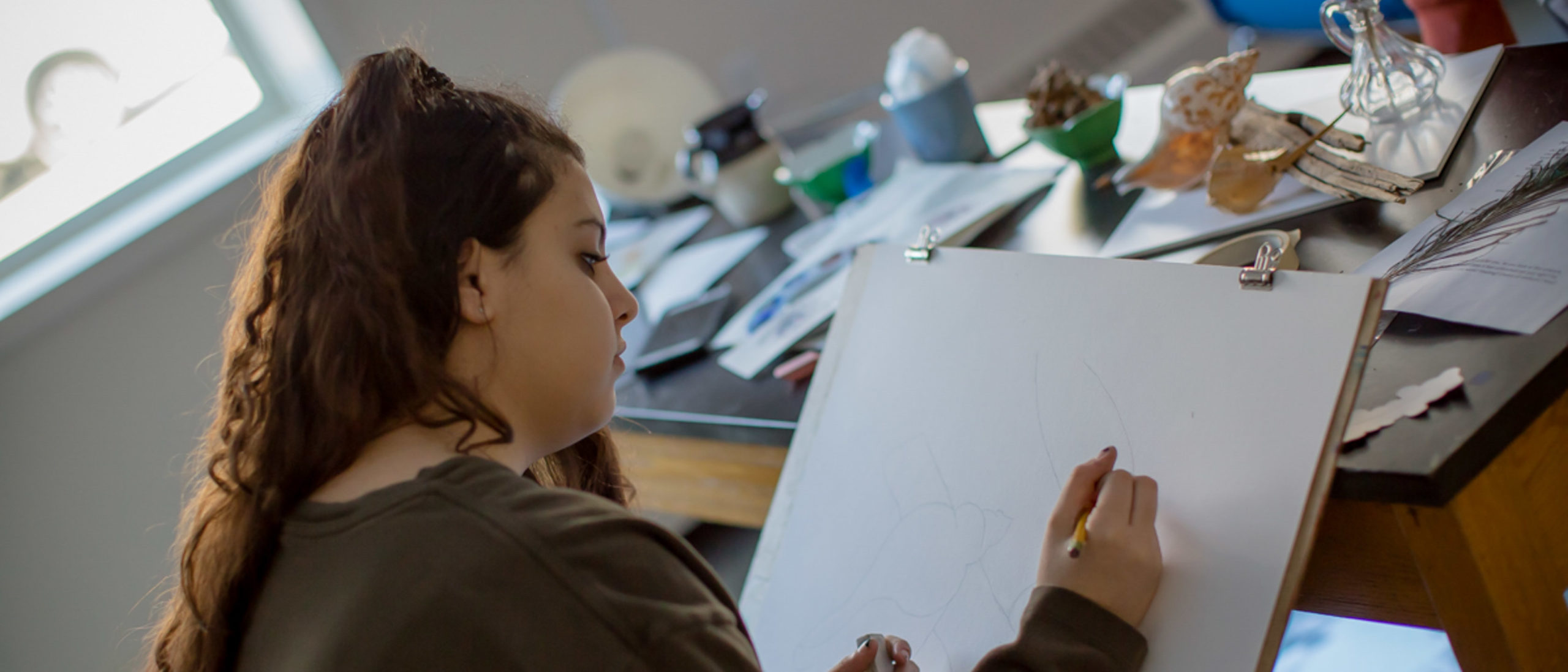 Female student drawing in art class