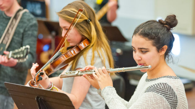 Student playing the flute in an orchestra practice