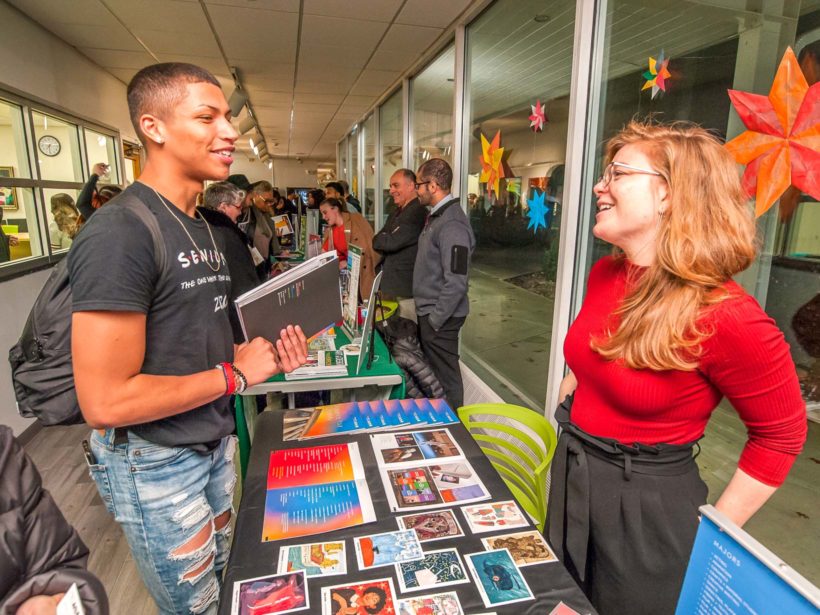 Student speaking to a college representative at a booth