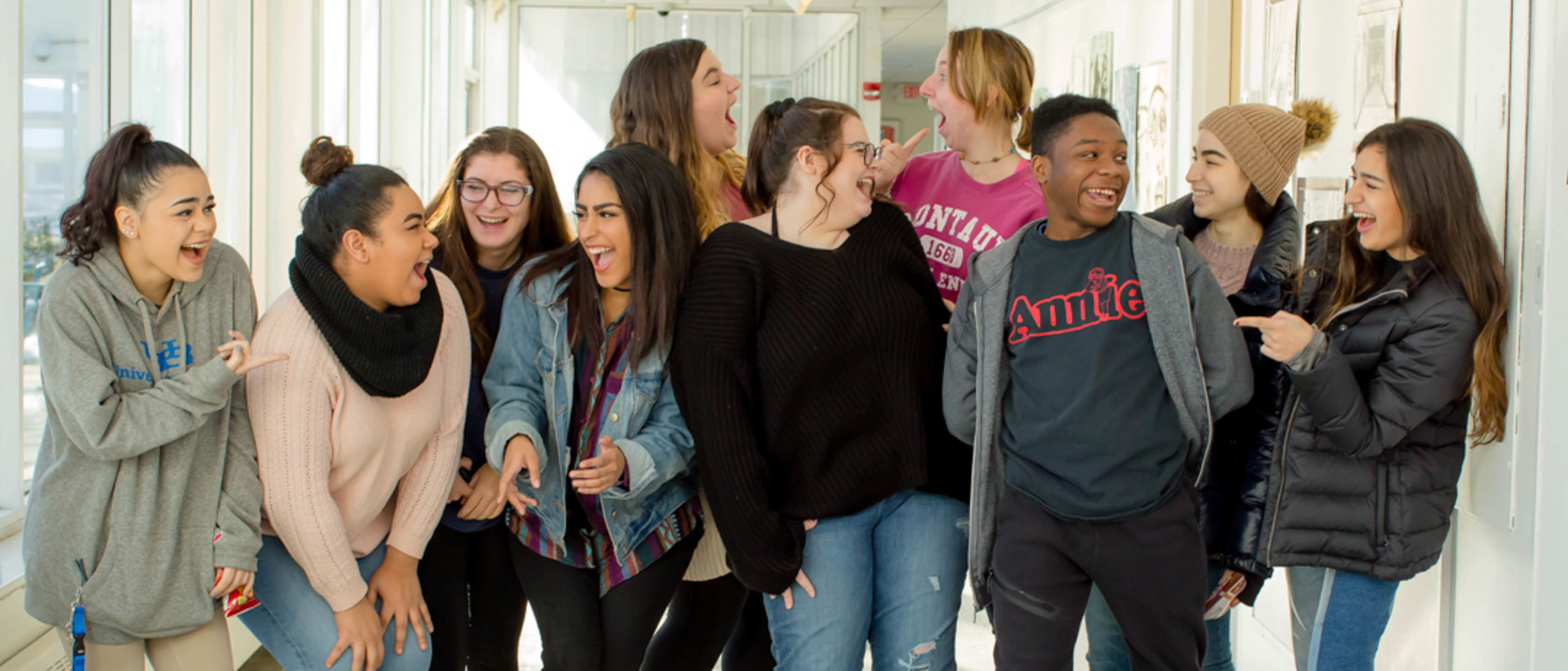 Group of students in the hallway laughing together