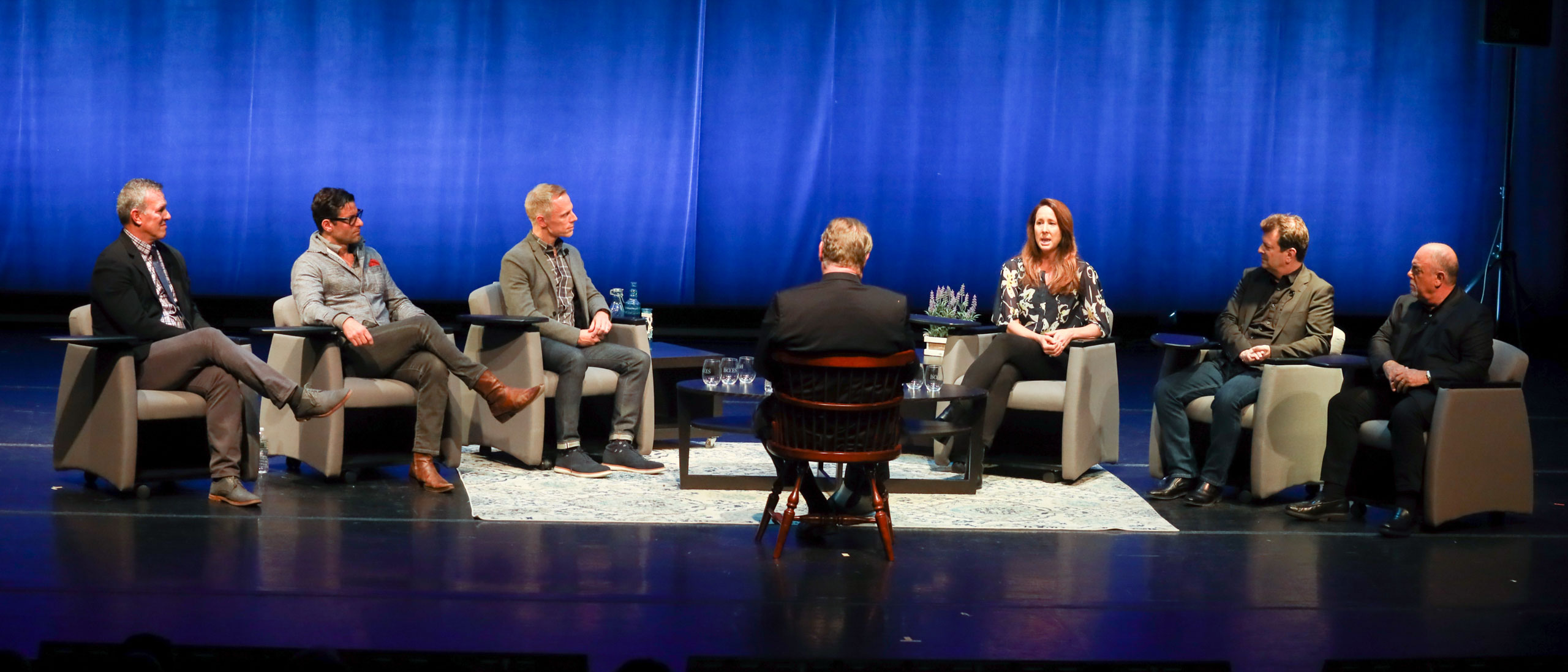 Advisors sitting in chairs on stage being interviewed