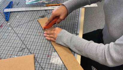 Production and Managerial Arts student cutting a piece of card boards