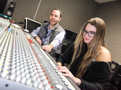 Sound engineer instructor teaching a student on the sound board