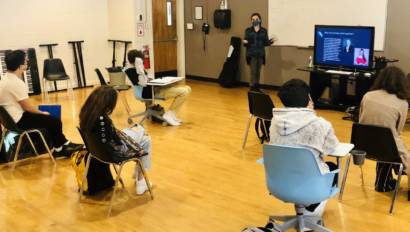 students socially distancing while watching presentation