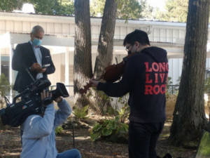 LIHSA student being filmed while playing the violin