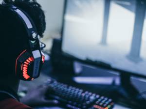 person wearing headphones while looking at a computer screen playing a video game