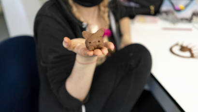 student holding a clay sculpture