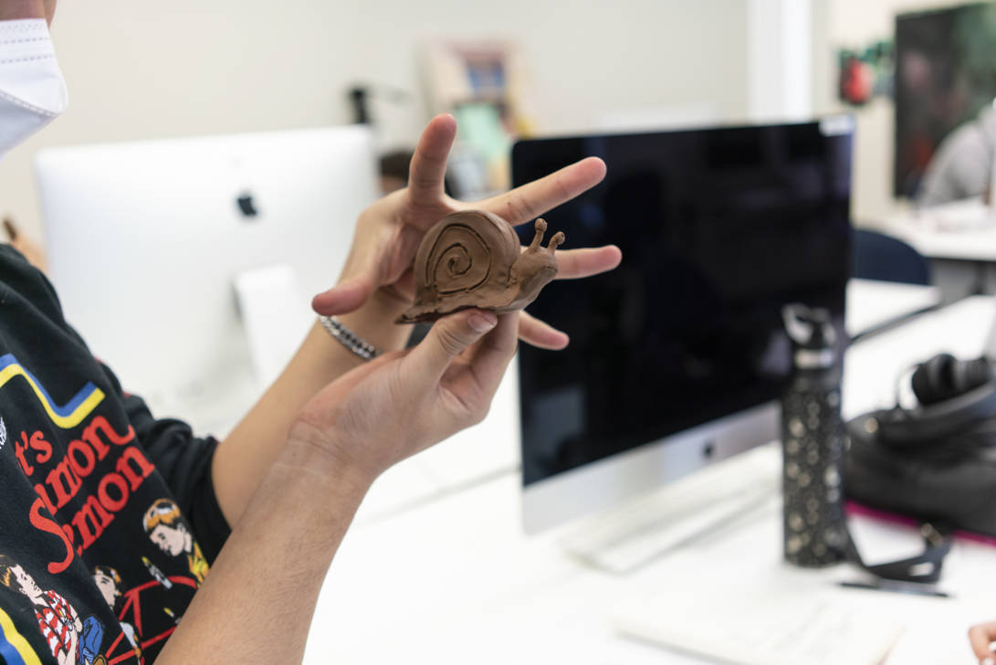 woman holding a brown clay snail