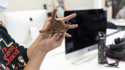 woman holding a brown clay snail