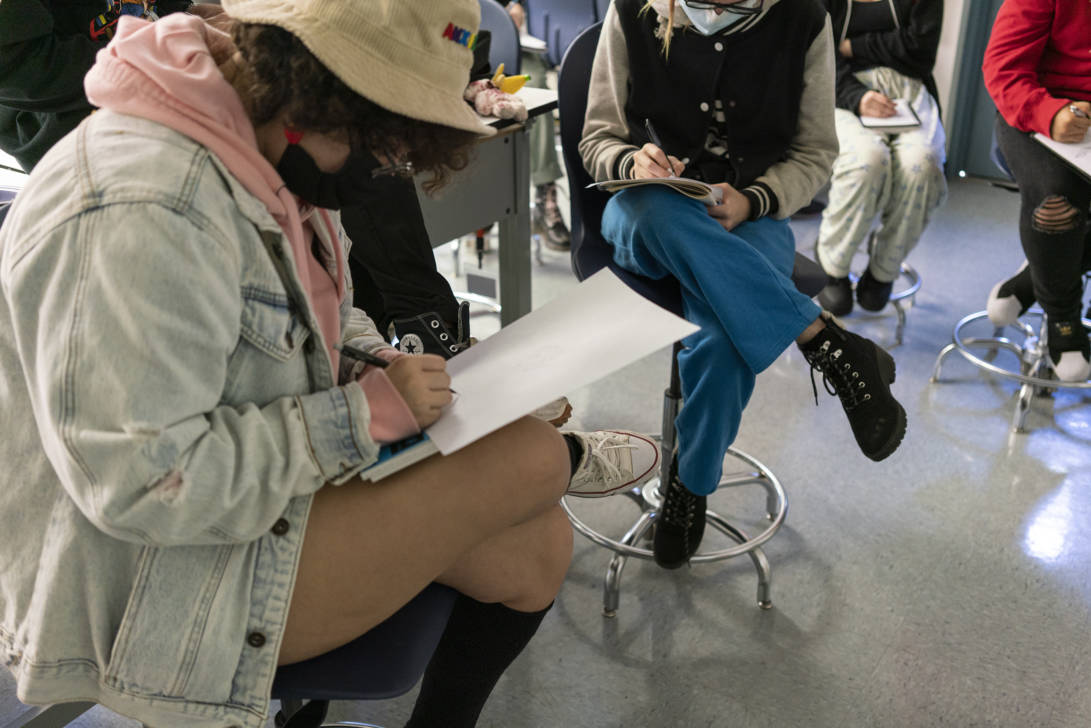 students sketching on paper during class