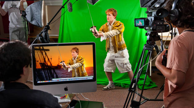 man sword fighting in front of a green screen