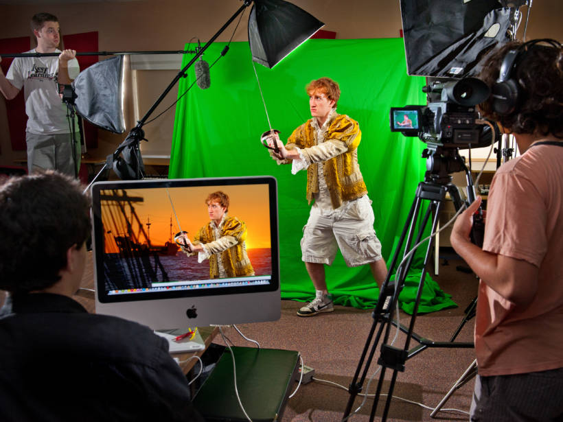 man sword fighting in front of a green screen