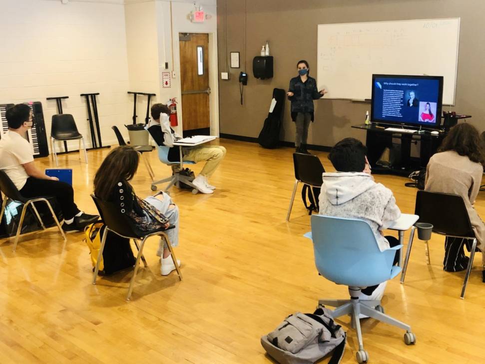 students socially distancing while watching presentation